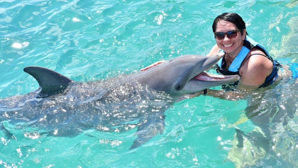 mujer nadando con un delfin