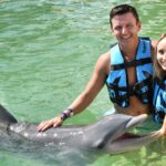 pareja nadando con un delfin en mexico
