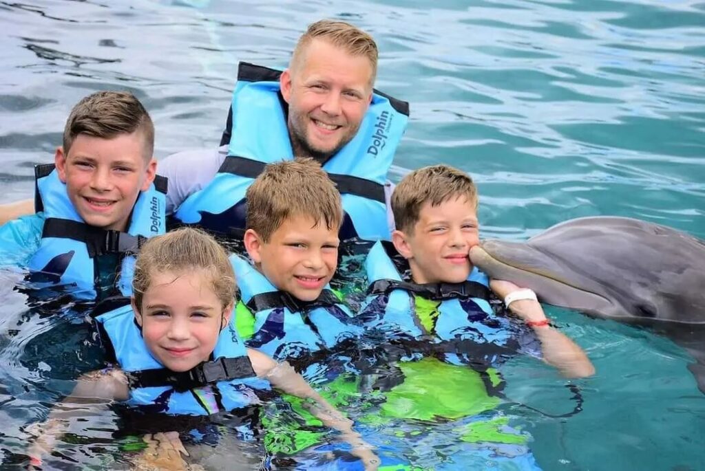familia nado con delfines