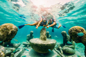 pareja haciendo snorkel en el museo subacuatico del arte en cancun