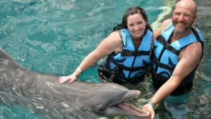 pareja nadando con delfines en cozumel